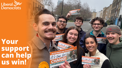 Jacob and supporters holding leaflets and smiling. Liberal Democrat logo in top left corner. Text on left, over an orange fade, says "Your support can help us win!"